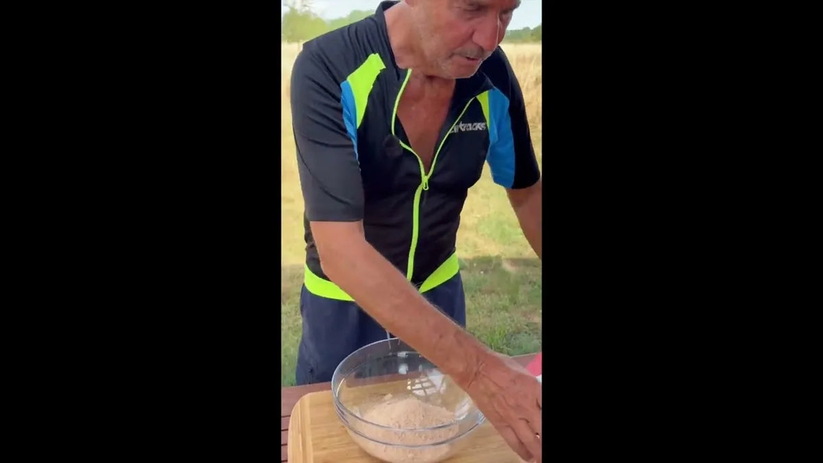 Ein Mann rührt draußen auf einer Wiese KIVEGAN Drymix in einer Glasschüssel an
